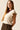 Top beige con volantes en las mangas